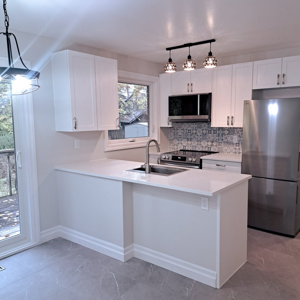 a clean photo of a kitchen with a new island floor and appliances in Ottawa recently renovated by Keith Gagnier Propert Owner Services