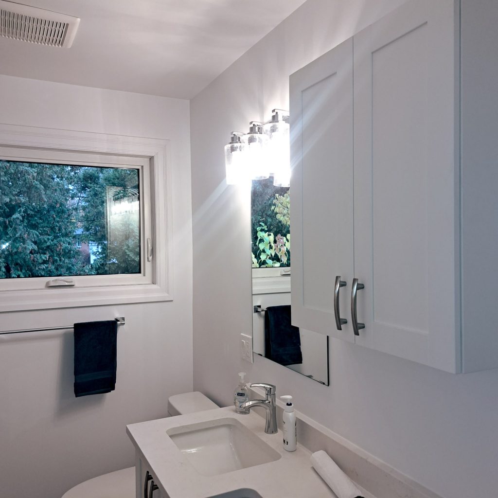 Photo of a completed bathroom renovation by Keith Gagnier Property Owner Services featuring new cabinetry, lighting, and plumbing 